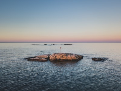 海洋中岩石上的红旗风景摄影